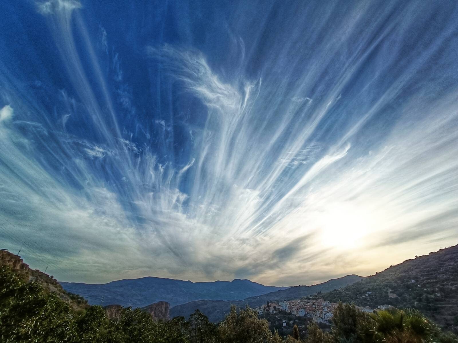 A photo showing the town of Lanjaron in Andaluica with mountains in distance and some clouds moving through