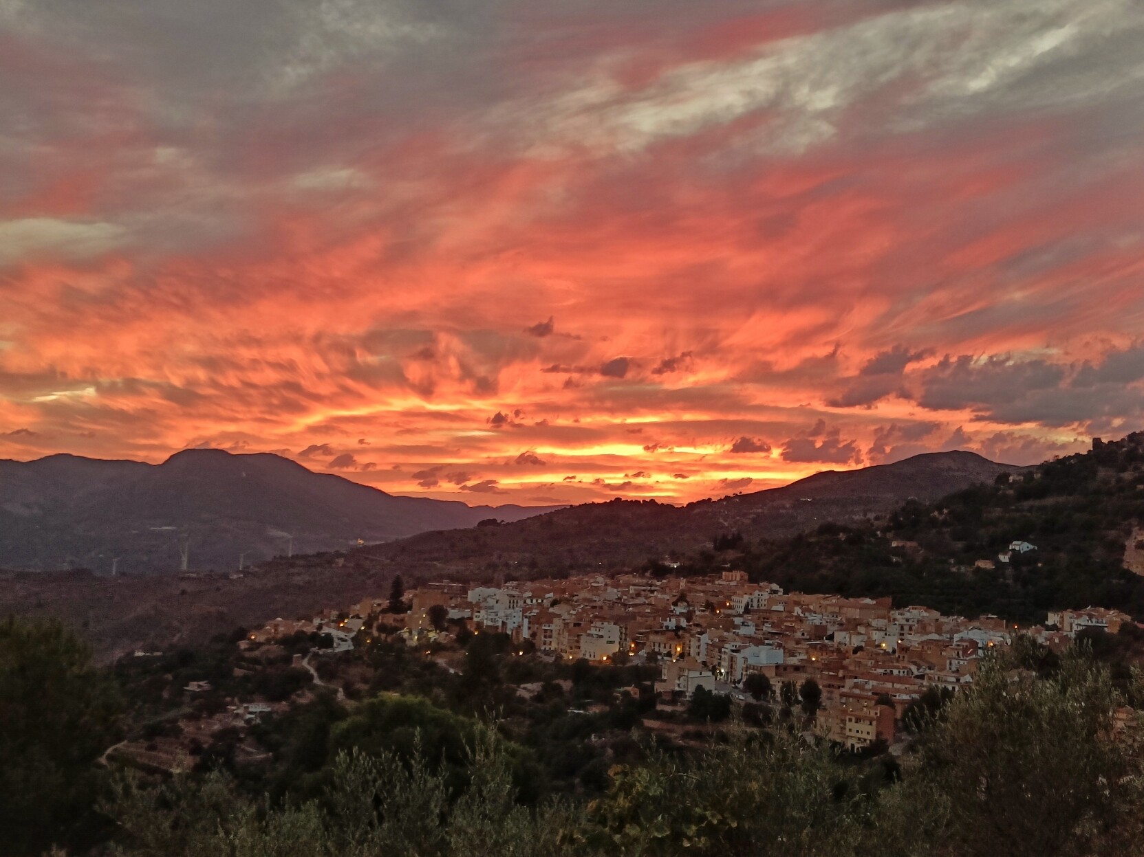 A deep orange sunset above an Andalucían white village